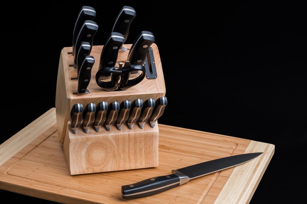 bloc_de_couteaux_sur_planche_en_bois_avec_arriere_plan_noir
