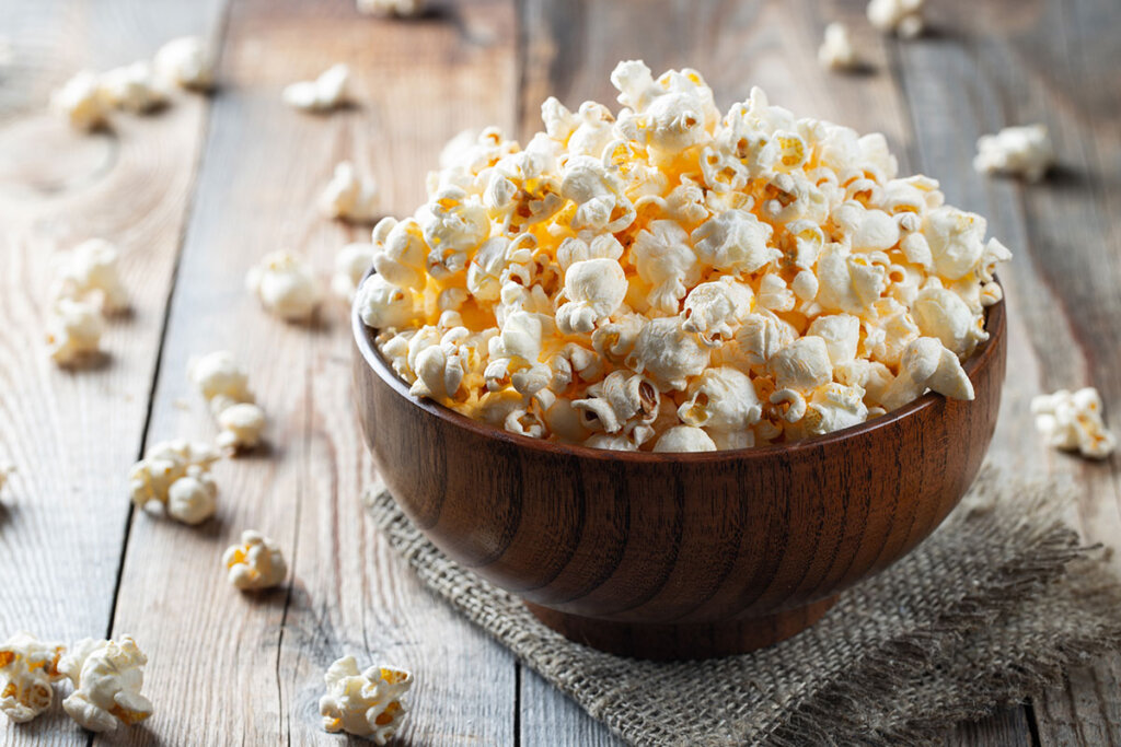 Pop-corn frais dans un bol en bois sur une table en bois
