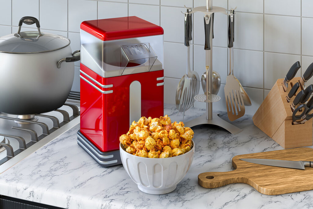 La machine à pop-corn et le bol plein de pop-corn se trouvent dans la cuisine