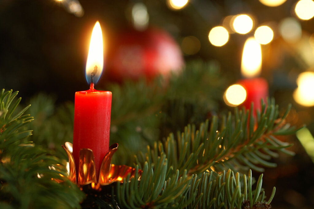 Une bougie de sapin de Noël allumée dans le sapin de Noël